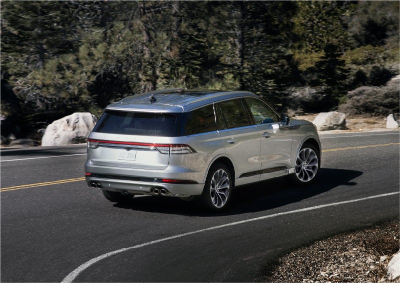 A 2023 Lincoln Aviator® Grand Touring model is shown being driven on a tight turn of a mountain road | Sheehy Lincoln of Richmond in Richmond VA