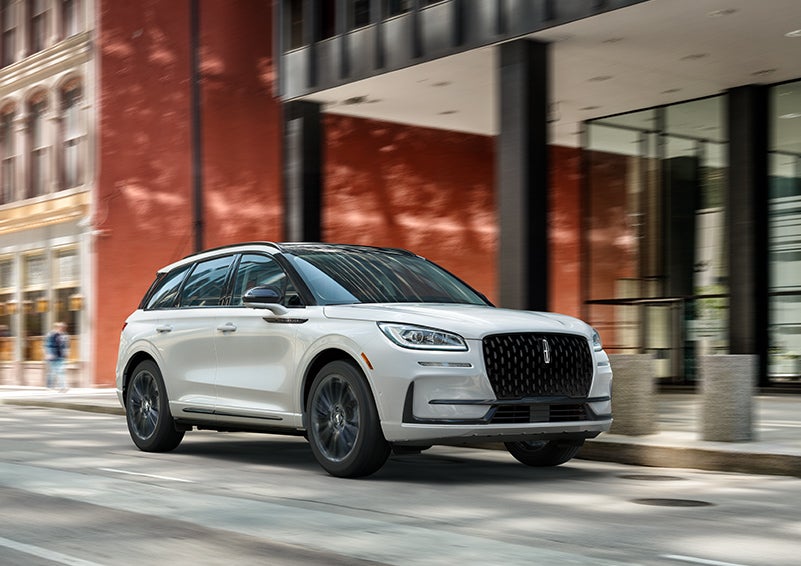 The 2024 Lincoln Corsair® SUV with the Jet Appearance Package and a Pristine White exterior is parked on a city street. | Sheehy Lincoln of Richmond in Richmond VA